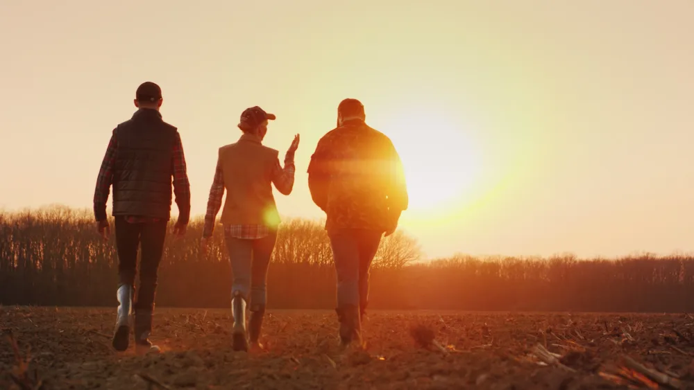 Farmers walking into a sunset. 