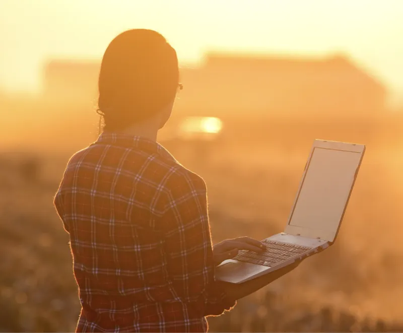 Farmer reviewing their data on a laptop. 