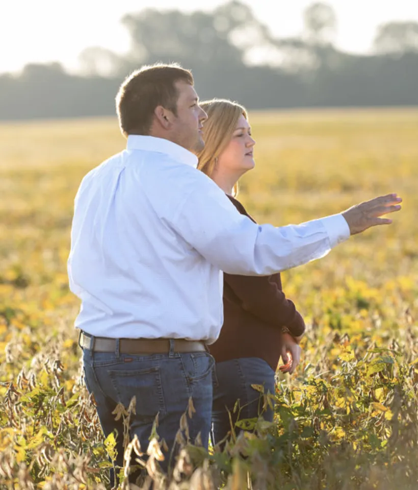 Farmers standing in their field of crops. 