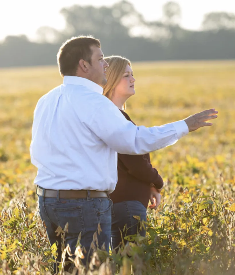 Farmers standing in their field of crops. 